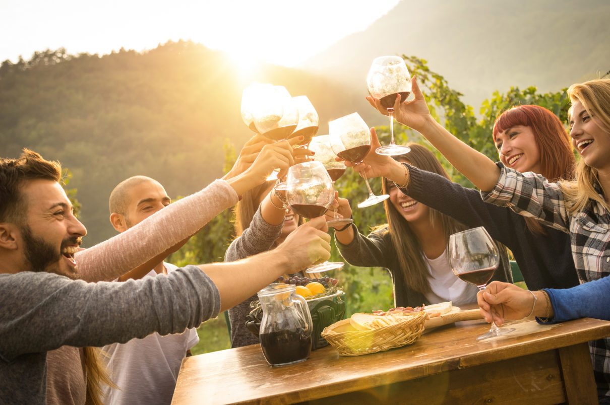 Happy friends having fun an drinking wine in autumn time we love our wine